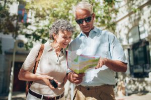 Middle aged couple using city map during vacation. Senior couple looking at a map while sightseeing.