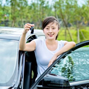 Young asian woman driver showing car keys.